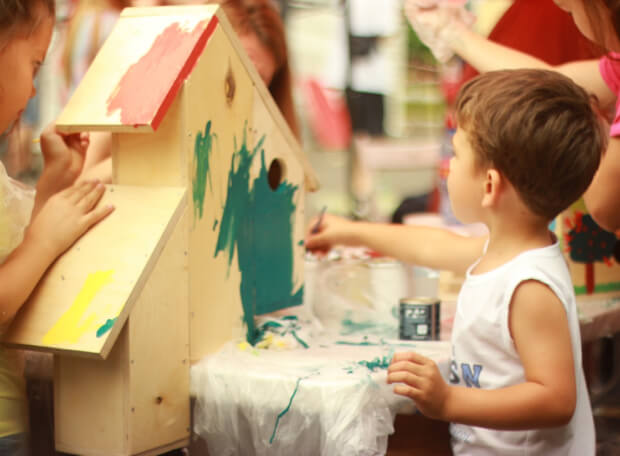 Daycare image of boy playing with paint